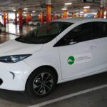 Un Ecotxe blanc, model Renault Zoe, dins un aparcament soterrani vist de perfil. Aquest és un dels cotxes de lloguer per hores de la cooperativa que té a Palma, Mallorca.