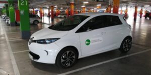 Un Ecotxe blanc, model Renault Zoe, dins un aparcament soterrani vist de perfil. Aquest és un dels cotxes de lloguer per hores de la cooperativa que té a Palma, Mallorca.